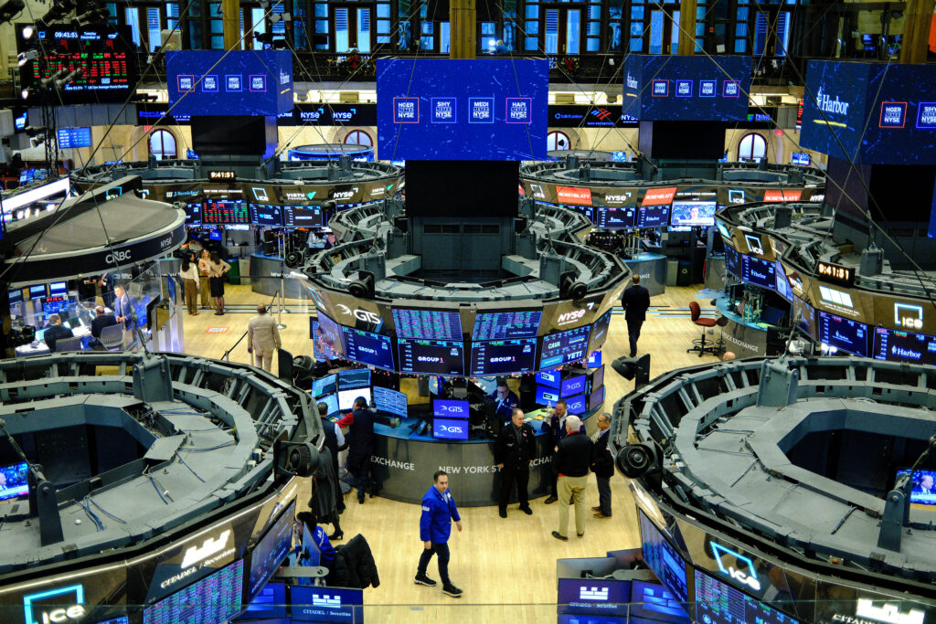 Transcendent Prosperity - Traders and digital screens fill the floor of the New York Stock Exchange, displaying financial data and stock prices in a busy trading environment.